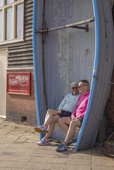 Two men sitting outside the Brighton Fishing Musuem. Credit - James Ratchford
