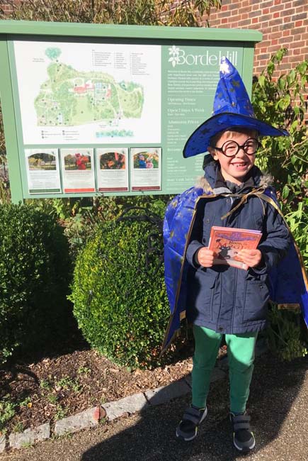 Boy in Halloween costume in front of Borde Hill map board