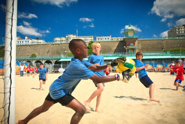 Children playing Beach volleyball on the sand.