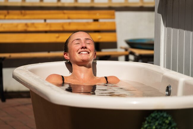 Image shows sauna goer in an outside plunge bath.