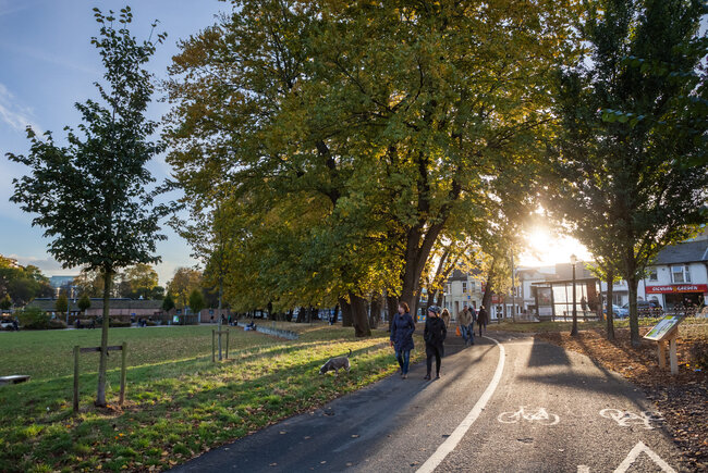 Image shows the Level in Brighton, pedestrians walk in the sunset. 