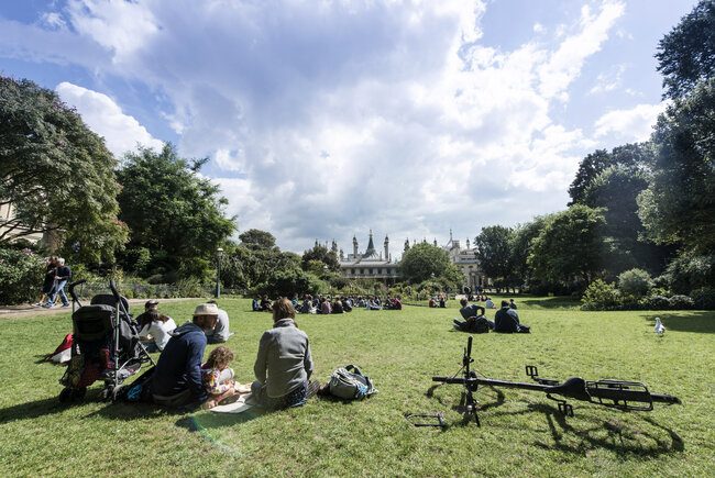 Visitors relax in the sun at The Royal Pavilion Gardens, Brighton