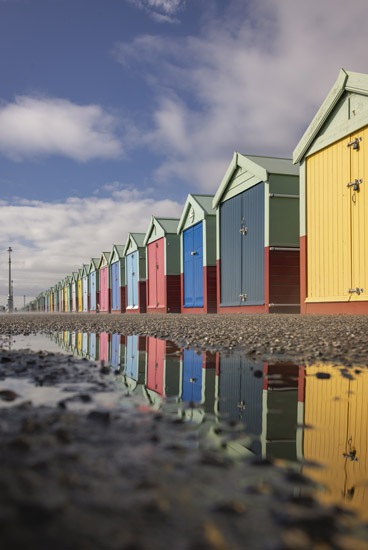 Hove beach huts reflected in a puddle taken by James Ratchford
